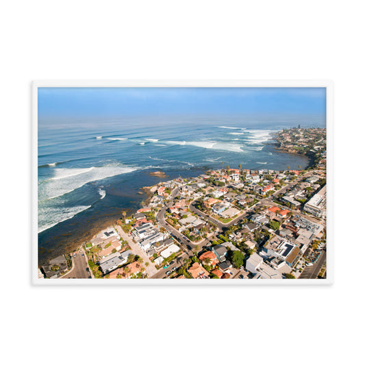 Bird Rock's neighborhood streets meet rocky headlands and a line of breaking surf in this coastal panorama in La Jolla; white frame, 24 × 36 inches.