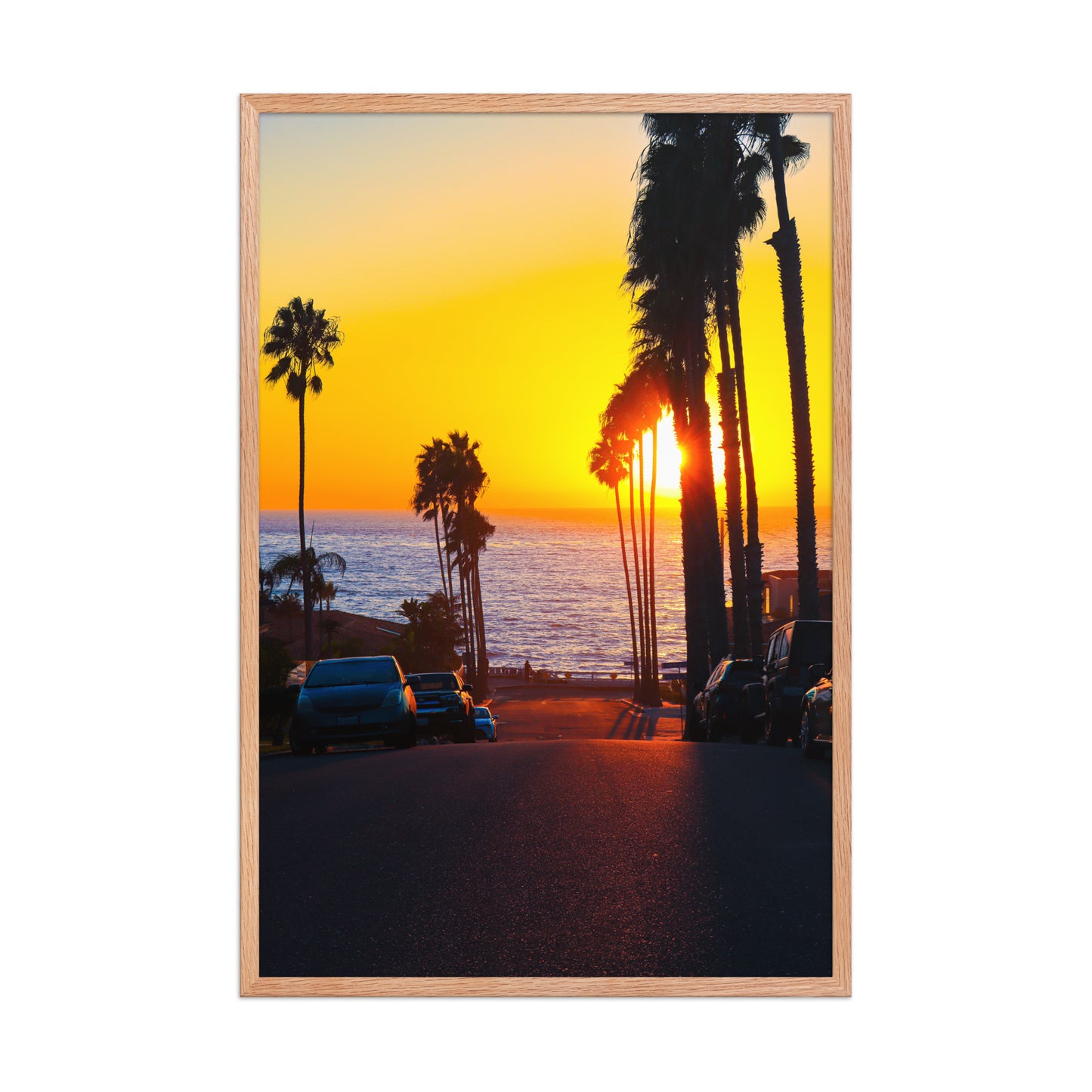 A golden sunset glows at the end of Palomar Avenue, framed by coastal palms and neighborhood silhouettes in La Jolla; wood frame, 24 × 36 inches.