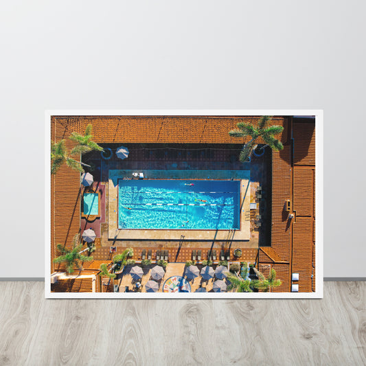 The Beach Club swimming pool forms a bright blue rectangle among lounge chairs, umbrellas, and palms in La Jolla; white frame, 24 × 36 inches.